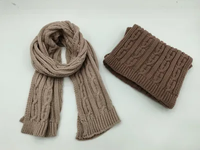 Beigefarbener Zopfstrickschal und brauner gefalteter Snood-Halswärmer auf weißem Hintergrund, Winteraccessoires-Set