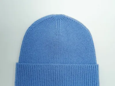 Weiche Strickmütze in hellem Kornblumenblau mit gefaltetem Rippenrand auf hellgrauem Untergrund