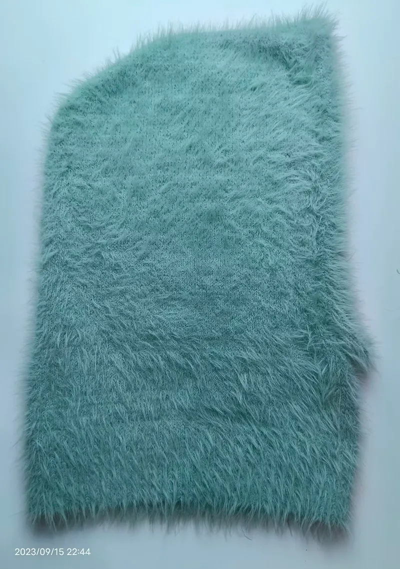 Mintgrüner Kunstfell-Stoff mit langem fluffigem Flor in Nahaufnahme auf weißem Hintergrund