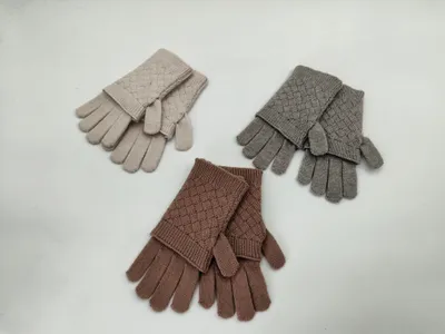 Drei Paare Strickhandschuhe mit Rautenmuster in den Farben Beige, Grau und Mauve flach auf weißem Hintergrund