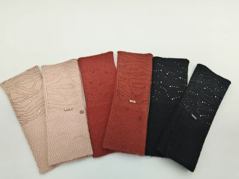 Sechs gestrickte Haarreife in Pink, Altrosa, Rost, Terrakotta, Anthrazit und Schwarz, fächerförmig angeordnet, mit Pailletten und Wellenstruktur