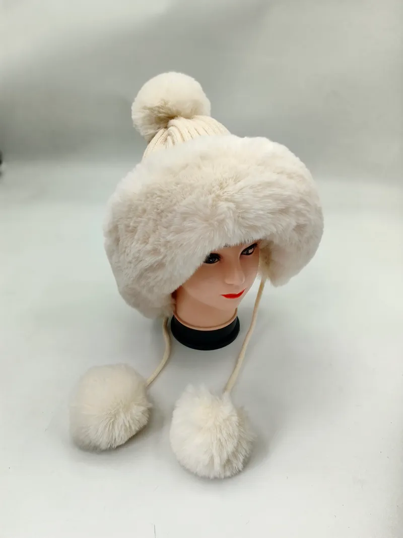 Weißer Kunstfell-Winterhut mit gestricktem Bommel an der Spitze und herabhängenden Pelz-Pompom-Bindebändern auf einer Hutform