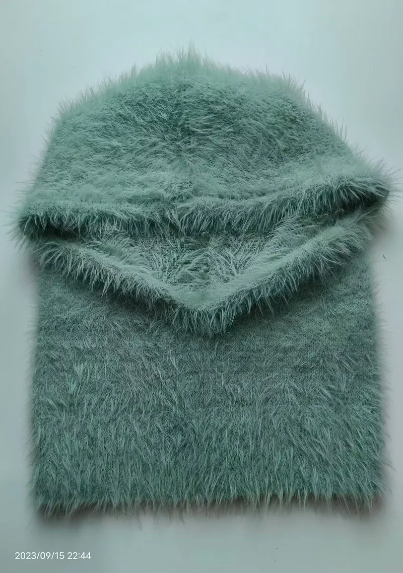 Gefaltete mintgrüne Flauschgarn-Balaclava mit passendem Schlauchschal auf weißem Hintergrund, Eyelash-Yarn-Textur sichtbar