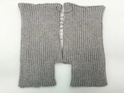Ein Paar hellgraue fingerlose Strickhandschuhe mit Rippenmuster, flach liegend auf weißem Hintergrund, offene Fingeröffnungen gut sichtbar