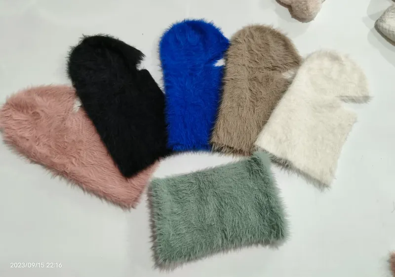 Sechs flauschige Kunstfell-Balaclavas in einem Fächer-Layout in Pink, Schwarz, Blau, Taupe, Creme und Salbeigrün
