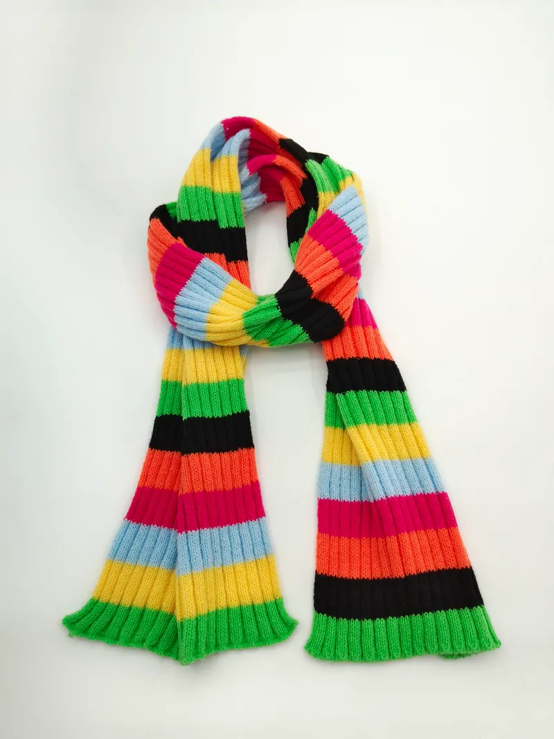 Langer Strickschal mit breiten bunten Querstreifen in Grün, Gelb, Orange, Pink, Blau und Schwarz auf hellem Untergrund
