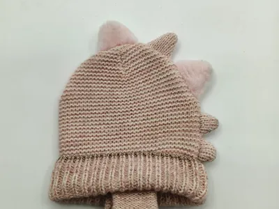 Rosafarbenes Baby-Winterset aus gestrickter Mütze mit flauschigen Einhorn-Pompom-Ohren und dazu passenden Handschuhen, flach auf weißem Hintergrund