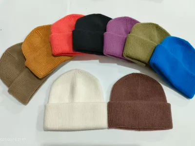 Kollektion aus 10 gerippten Strickmützen mit Umschlagbündchen in verschiedenen Farben wie Weiß, Schwarz, Rot, Blau, Lila, Olive, Braun und Kamel auf weißem Hintergrund
