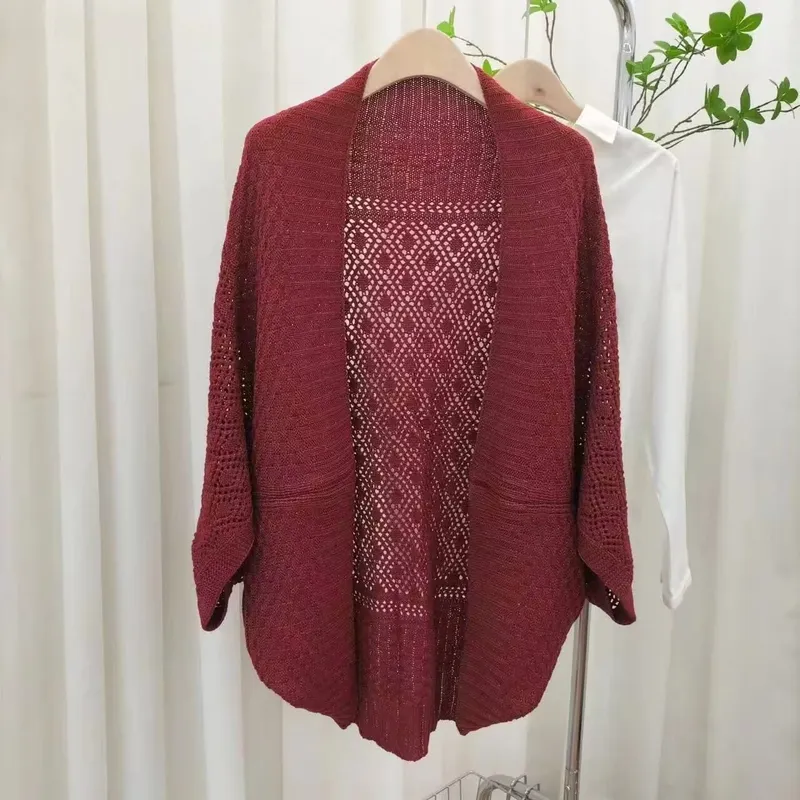 Burgunderrote offene Strickjacke mit Rautenspitzen-Häkelrücken und Dreiviertelärmeln auf einem Kleiderständer