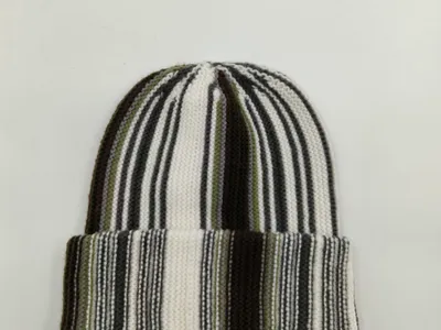 Klassische Strickmütze mit senkrechten Farbstreifen in Weiß, Schwarz und Olivgrün, umgeschlagener Krempe, flach fotografiert