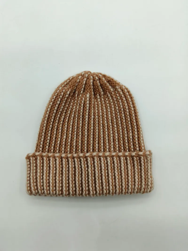 Gemütliche Strickmütze in warmen Erdtönen Camel und Creme mit breitem Umschlag, Flachaufnahme auf weißem Hintergrund
