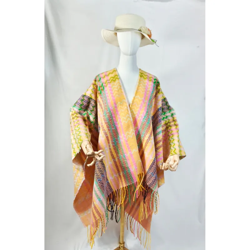 Schaufensterpuppe mit farbenfrohem Chevron-Muster-Umhang in Rosa, Gelb und Grün mit langen Fransenenden und weißem Sonnenhut