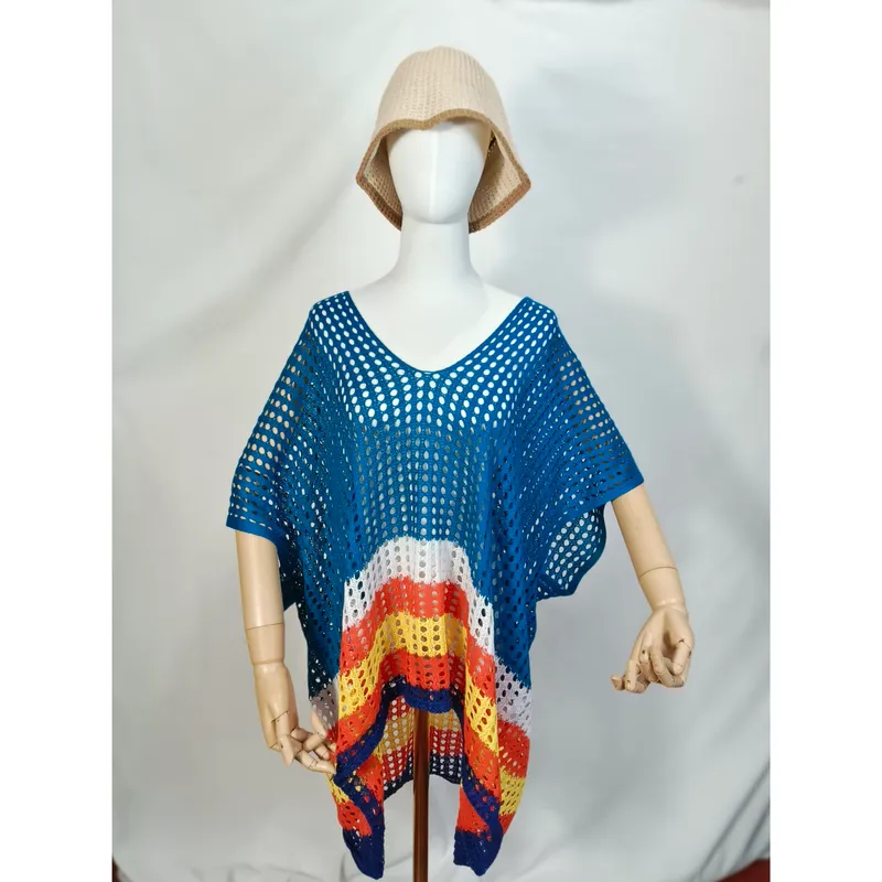 Schaufensterpuppe trägt Häkel-Strandponcho mit blauen, orangenen und gelben Streifen im offenen Netzmuster und Sonnenhut