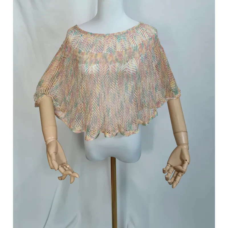 Pastellfarbener offenmaschiger Kurz-Poncho auf Schaufensterpuppe mit Holzarmen, farbenfrohe Häkeloptik in Rosa, Mint und Gelb