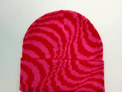 Strickmütze mit Zebra-Streifenmuster in Pink und Rot mit breitem Umschlagrand, Draufsicht auf weißem Hintergrund