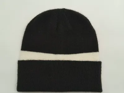 Schwarze Strickmütze mit cremefarbenem Querstreifen und doppelt umgeschlagenem Ripprand, flach auf weißem Untergrund
