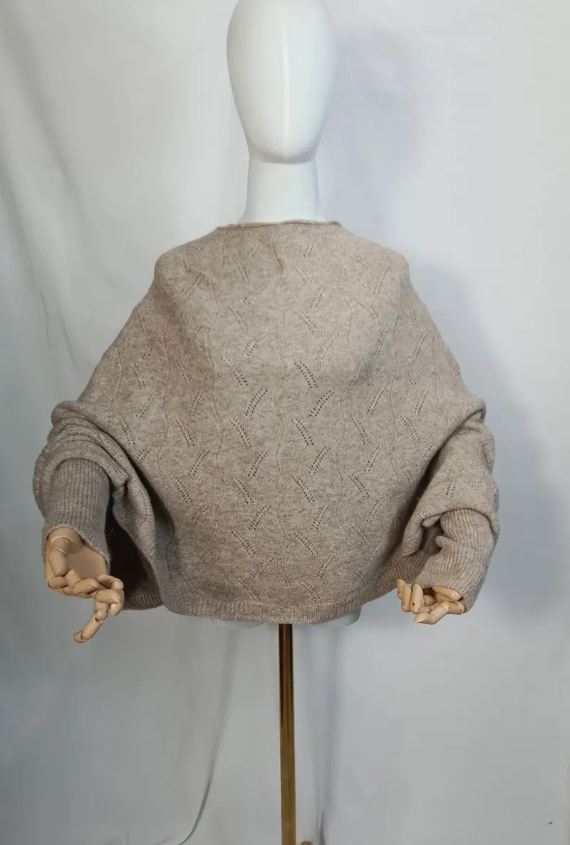 Rückenansicht eines weiten cremefarbenen Ajour-Strickpullovers mit Ballonärmeln und Rippbündchen auf weißer Schneiderpuppe
