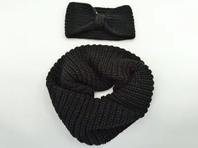 Schwarzer dicker Rundschal aufgerollt neben passendem Twist-Knotenband, beide mit bunten Metallic-Lurex-Fäden durchwebt