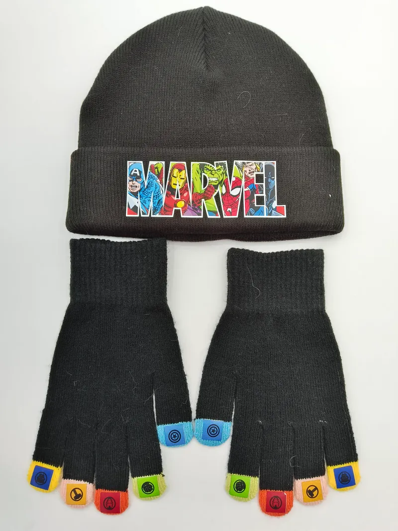 Schwarze Strickmütze mit Comichelden-Abzeichen und passende fingerlose Handschuhe mit bunten Fingerkuppen auf weißem Grund