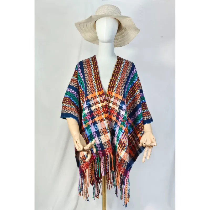 Schaufensterpuppe trägt farbenfrohen Ethno-Poncho mit geometrischem Webmuster und Fransensaum sowie cremefarbenem Schlapphut