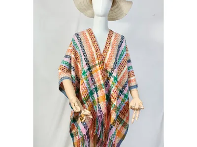 Schaufensterpuppe im mehrfarbigen geometrischen Webponcho mit Fransenkante und breiter Hutkrempe im Boho-Look