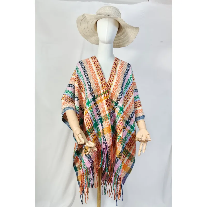 Schaufensterpuppe im mehrfarbigen geometrischen Webponcho mit Fransenkante und breiter Hutkrempe im Boho-Look