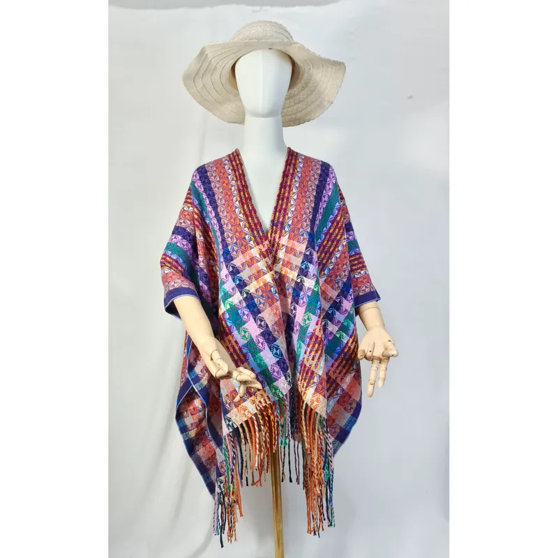 Schaufensterpuppe mit mehrfarbigem geometrisch gewebten Überwurf-Poncho und Fransensaum sowie Naturstrohhut