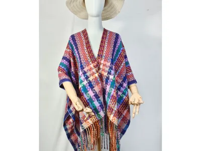 Schaufensterpuppe mit mehrfarbigem geometrisch gewebten Überwurf-Poncho und Fransensaum sowie Naturstrohhut