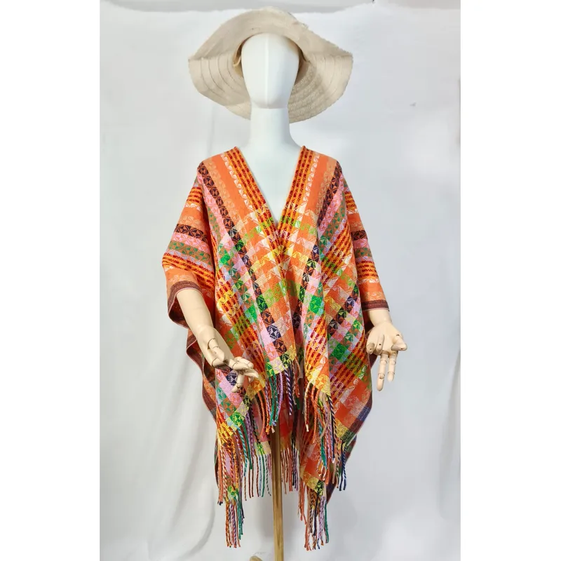 Weiße Schaufensterpuppe mit orangefarbenem handgewebten geometrischen Poncho mit Fransensaum und naturfarbenem Breitkrempen-Hut
