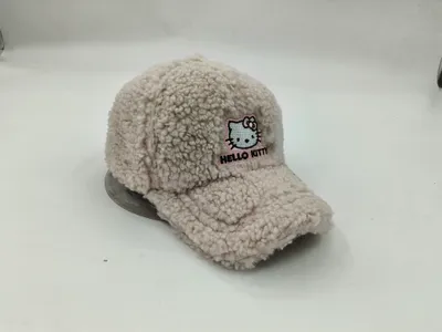 Flauschige Teddy-Fleece-Schirmmütze in Naturweiß mit gesticktem Cartoon-Katzengesicht und rosafarbenem Schriftzug