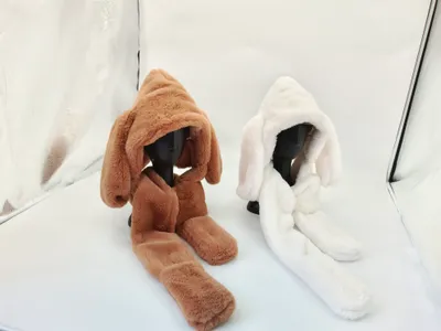 Braunes und weißes Kunstfell-Kapuzenset mit langen Hasenohren auf Schaufensterkopf, flauschiges Winteraccessoire in Studioaufnahme