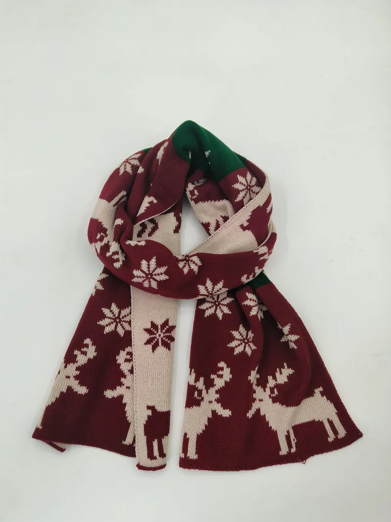 Weinroter und cremefarbener Strickschal mit nordischem Rentier- und Schneeflockendesign, drapiert auf weißem Hintergrund