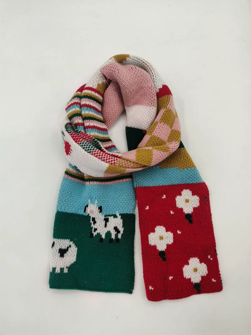 Farbenfroher Strickschal mit Schafs-Motiven, Blumenfeldern, Streifen und Patchwork-Segmenten in Rot, Grün, Blau und Pink