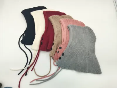 Sechs Rippstrick-Sturmhauben in Marine, Creme, Bordeaux, Beige, Rosa und Grau mit Knöpfen und Kordeln nebeneinander
