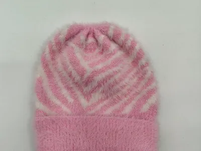 Rosa-weiße Flausch-Strickmütze mit geometrischem Chevron-Streifenmuster und umgeschlagenem Rand in Draufsicht auf weißem Hintergrund