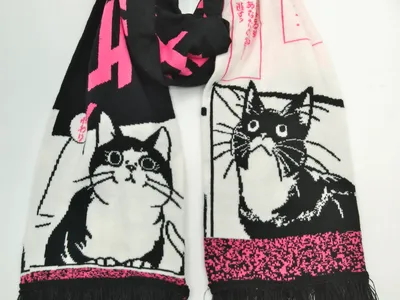 Gestrickter Winterschal mit schwarz-weißen Manga-Katzenzeichnungen, pinkfarbenen japanischen Schriftzügen und Fransenkanten