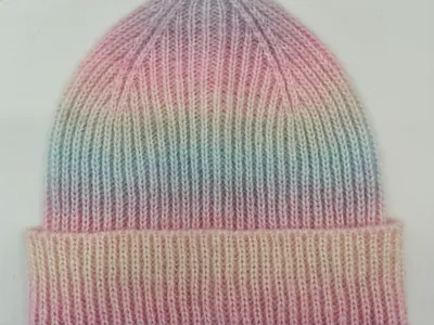 Gestrickte Wintermütze mit sanftem Farbverlauf in Pastellrosa, Lavendel, Mintgrün und Cremeweiß mit gefaltetem Rand