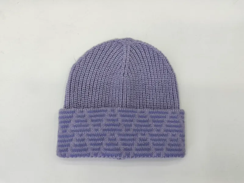 Lila Rippstrickmütze mit breitem gefaltetem Jacquard-Umschlag auf weißem Hintergrund