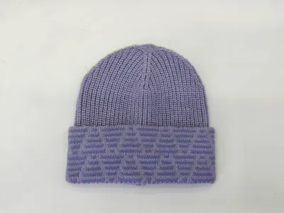 Lila Rippstrickmütze mit breitem gefaltetem Jacquard-Umschlag auf weißem Hintergrund