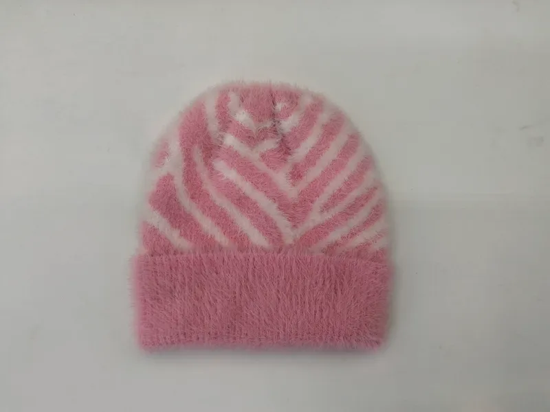 Pinke Felloptik-Wintermütze mit kontrastierendem weißem Zebraprint und Umschlagrand auf weißem Untergrund