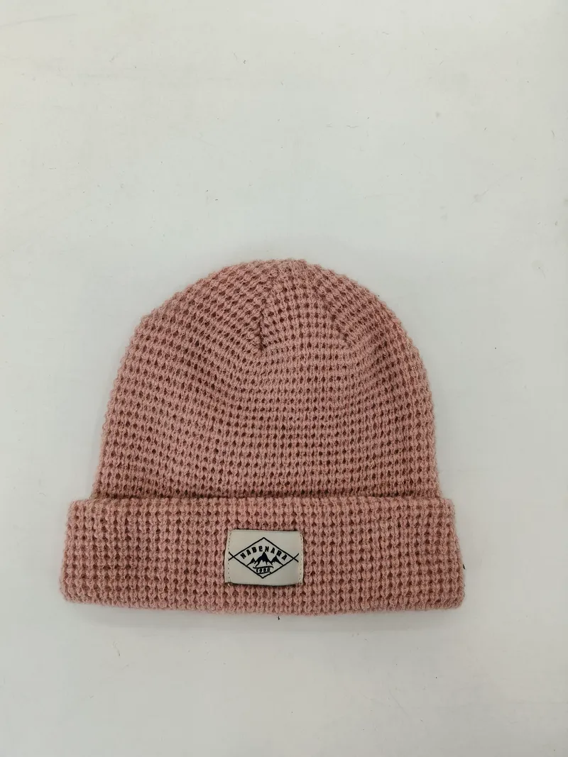 Strickmütze in Altrosa mit Waffelstruktur, umgeschlagenem Bund und gewebtem Etikett-Patch, Draufsicht auf weißem Untergrund