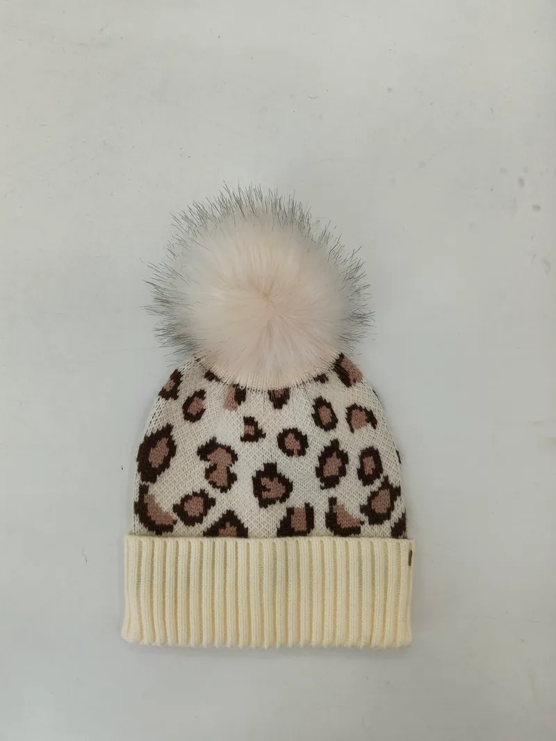 Cremeweiße Strickmütze mit braunem Leopardenmuster, geripptem Bündchen und flauschigem weißem Kunstfell-Pompon