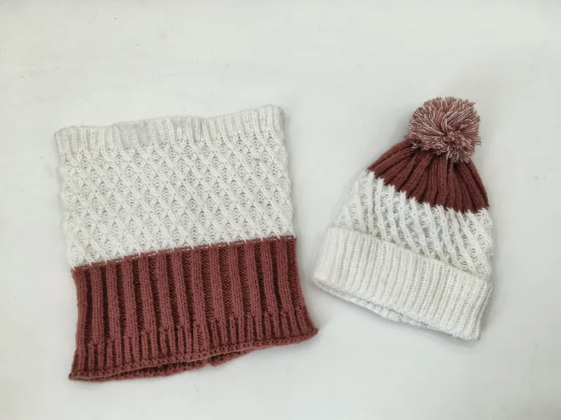 Winterset aus gestricktem Schlauchschal mit Rautenmuster in Creme und Mauve sowie passender Bommel-Mütze, Draufsicht auf weißem Untergrund