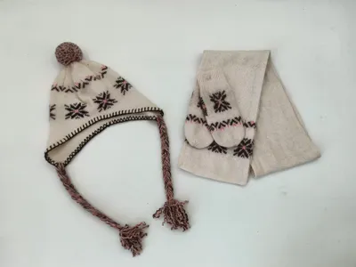 Dreiteiliges Strickset in Creme mit Schneeflocken-Muster, Ohrenklappenmütze mit Zopfquasten, Fäustlinge und passender Schal