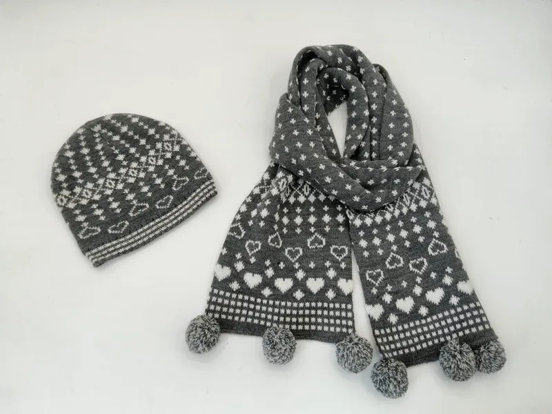 Grau-weißes Strickset im Fair-Isle-Stil mit Herzchen-Motiven, Bommel-Mütze und passendem Schal mit Bommelenden, Draufsicht