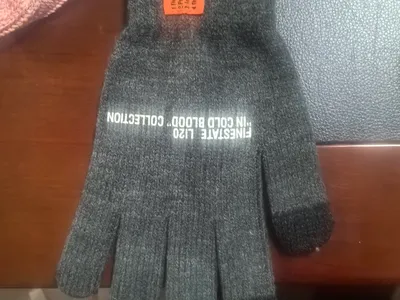 Dunkelgraue melierte Strickhandschuhe mit weißem Schriftaufdruck und touchscreenkompatiblen Fingerkuppen, flach fotografiert