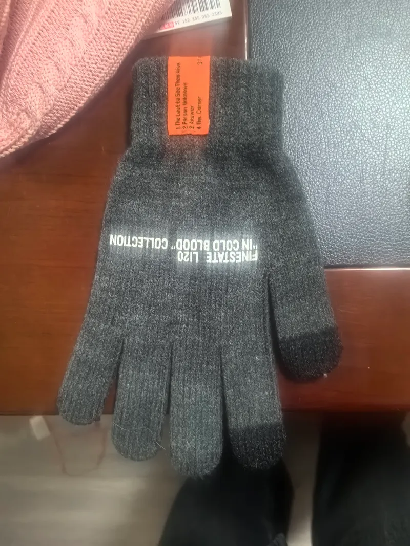 Dunkelgraue melierte Strickhandschuhe mit weißem Schriftaufdruck und touchscreenkompatiblen Fingerkuppen, flach fotografiert