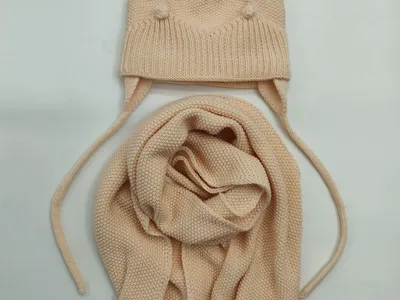 Cremefarbenes Kinderstrick-Set: Beanie mit Pompon und Ohrenschutz sowie zugehöriger Strickschal mit Pomponenden