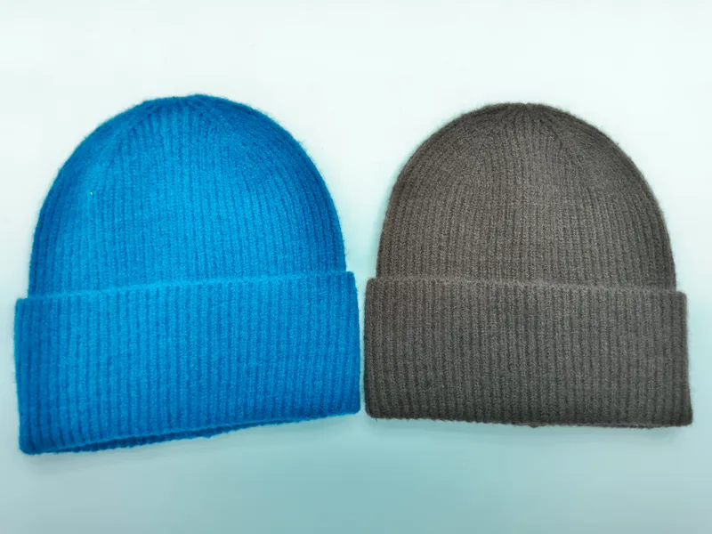 Zwei Umschlagbeanies aus Rippenstrick in leuchtendem Blau und warmem Hellbraun auf weißem Hintergrund nebeneinander
