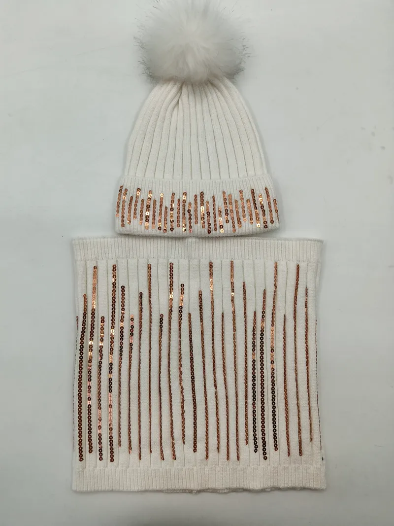 Weiße Rippenstrickmütze mit flauschigem Kunstfell-Bommel und Rosegold-Paillettenstreifen, kombiniert mit passendem Schlauchschal